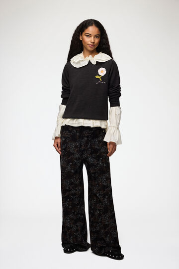 Model wearing sweater with flower