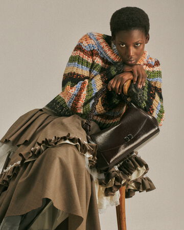 Model wearing striped knit and brown skirt from the Fall/Winter 2026 collection