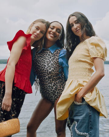 Models standing by water, wearing GANNI summer collection