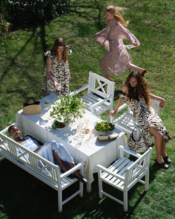 Models sharing a candid lunch at an outdoor garden table
