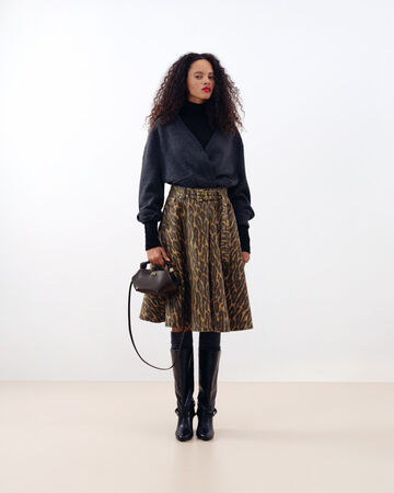 Model in leopard skirt holding a bag