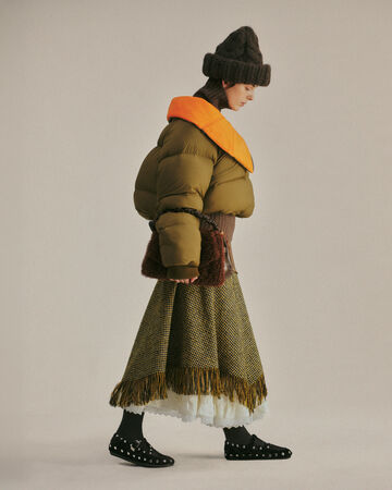 Model wearing a green puffer and skirt from the Fall/Winter 2026 collection