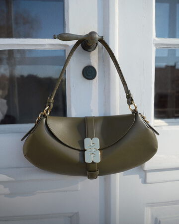 Olive green GANNI B-Kat shoulder bag on a doorknob