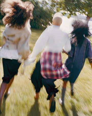 Models running in garden, wearing new GANNI collection