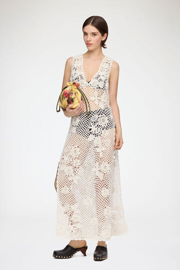 Model wearing long white crochet dress