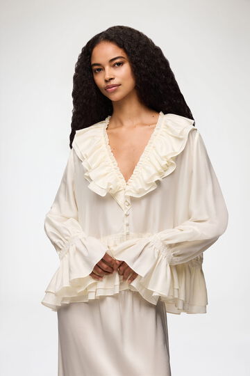 Model wearing white ruffle shirt