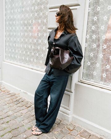 Girl wearing GANNI blazer and jeans, holding a XXL Hobo bag