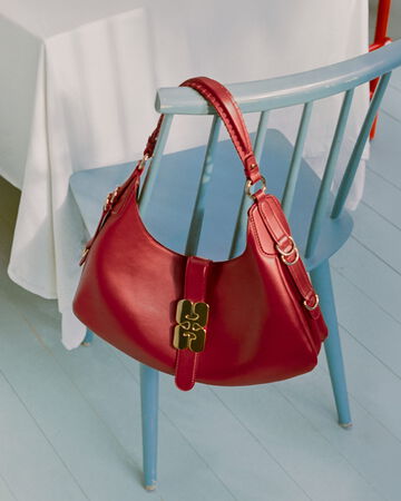 GANNI Kat bag in red hanging on chair