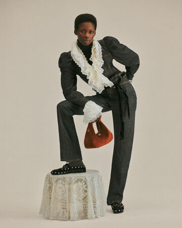 Model wearing grey suit and knit lace shirt from the Fall/Winter 2026 collection