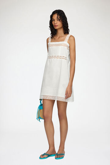 Model wearing short white cotton dress