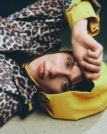 Model wearing GANNI x Hunter poncho