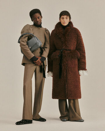 Two models wearing a beige set and brown fur coat from the Fall/Winter 2026 collection